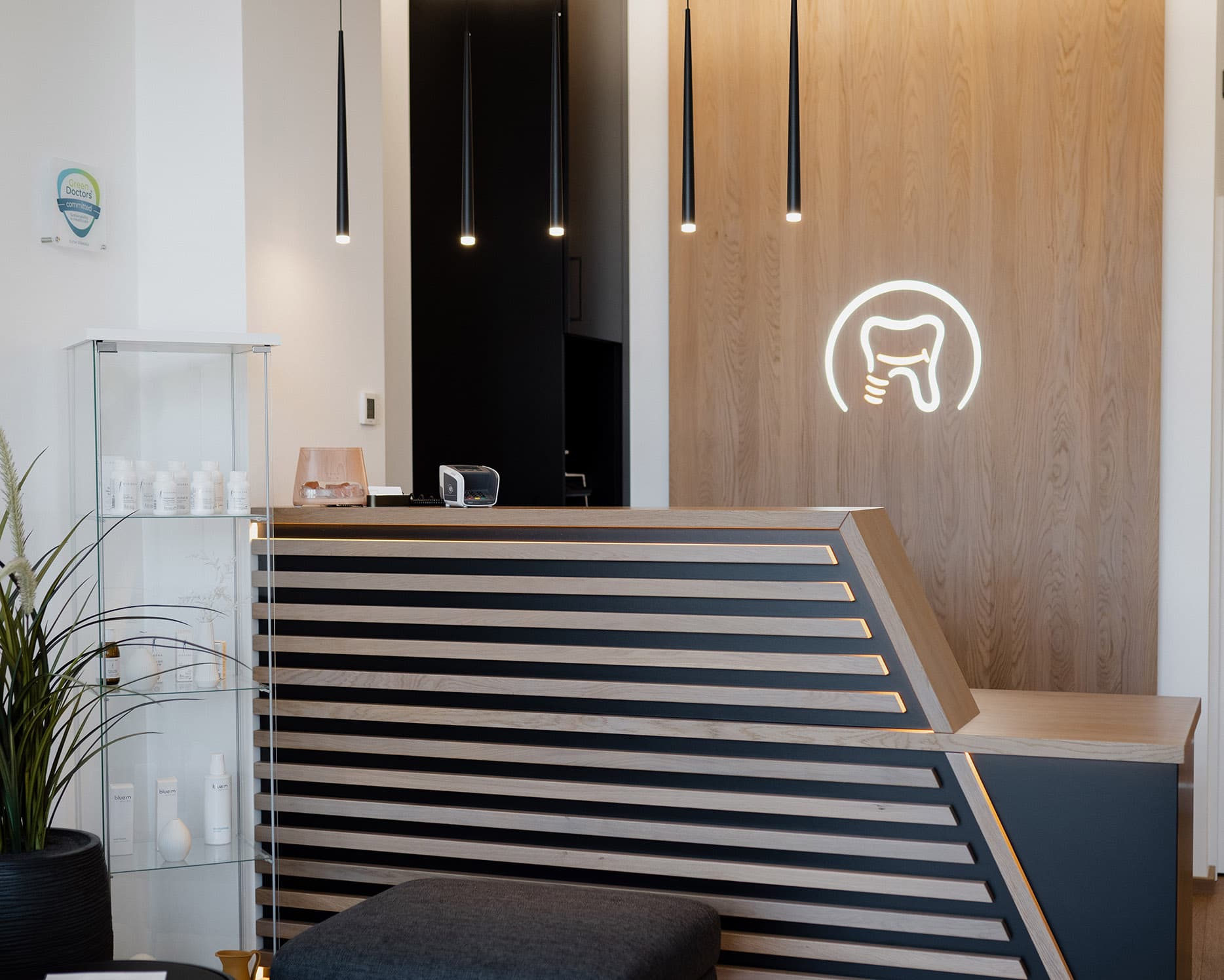 Empfang im Reinisch Zentrum mit Holzwand und beleuchtetem Logo